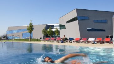 Mann schwimmt im Sportbecken der Therme Wien