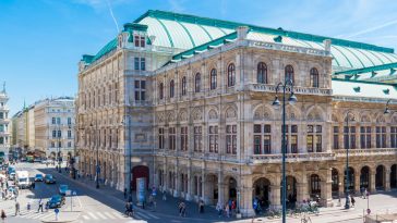 state opera house on albertina square with people and traffic in downtown vienna, austria