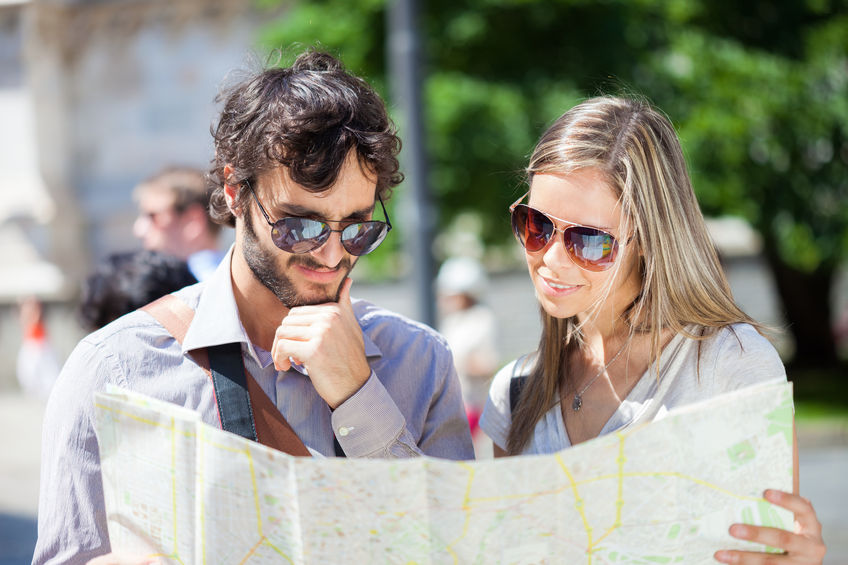 couple of young tourists reading a map