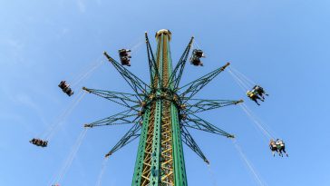 people having fun in carousel swing ride at amusement park