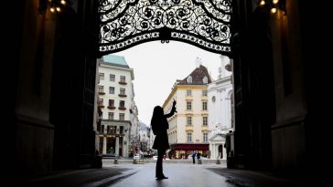 woman using gadget in hofburg vienna, silhouette, wide angle