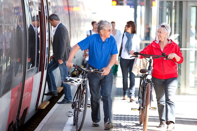 ältere Personen mit dem Fahrrad am Bahnsteig