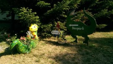 Einganbsbereich des Familienpark mit kleinem Dino und Schild